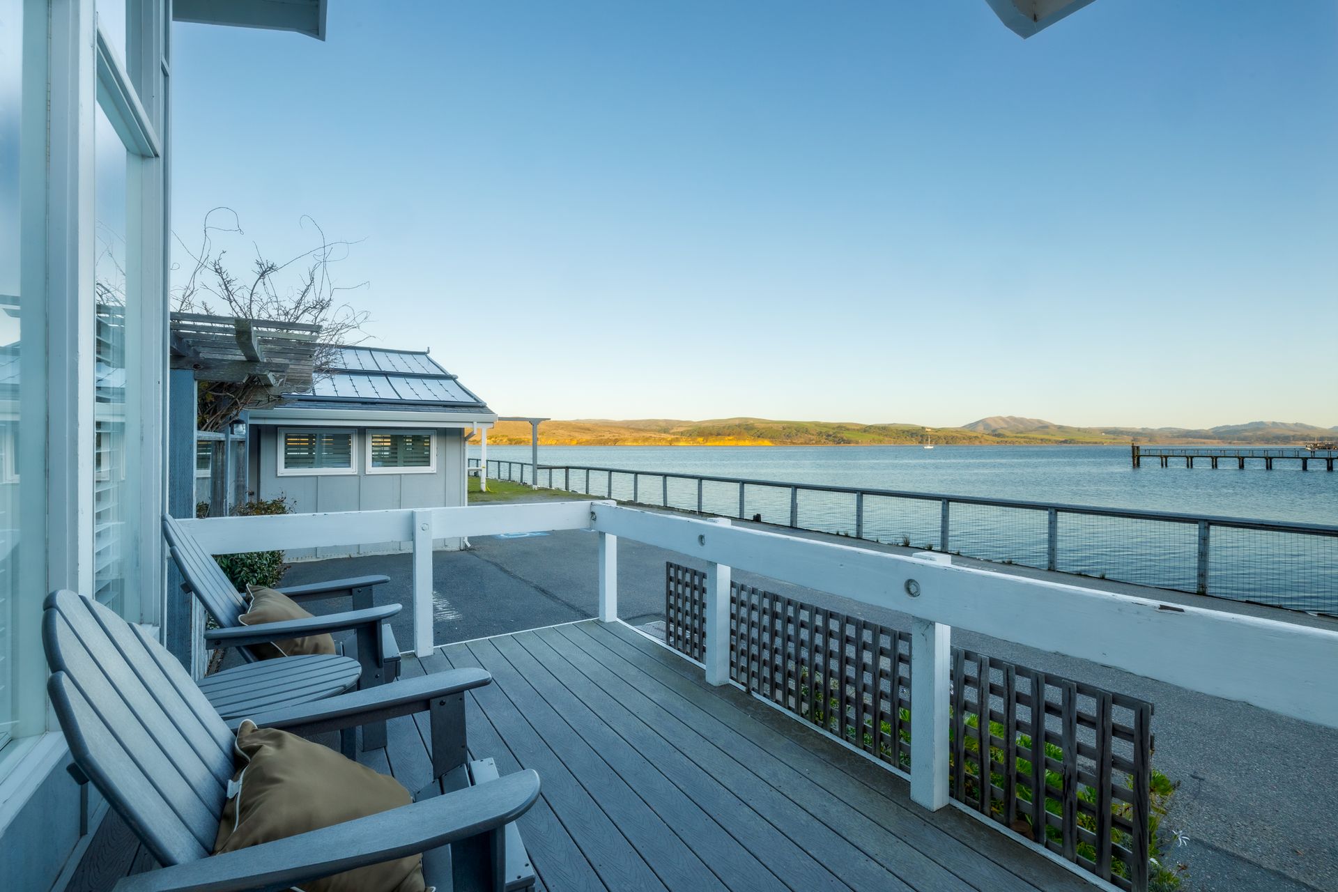 A deck with chairs and a view of a body of water.