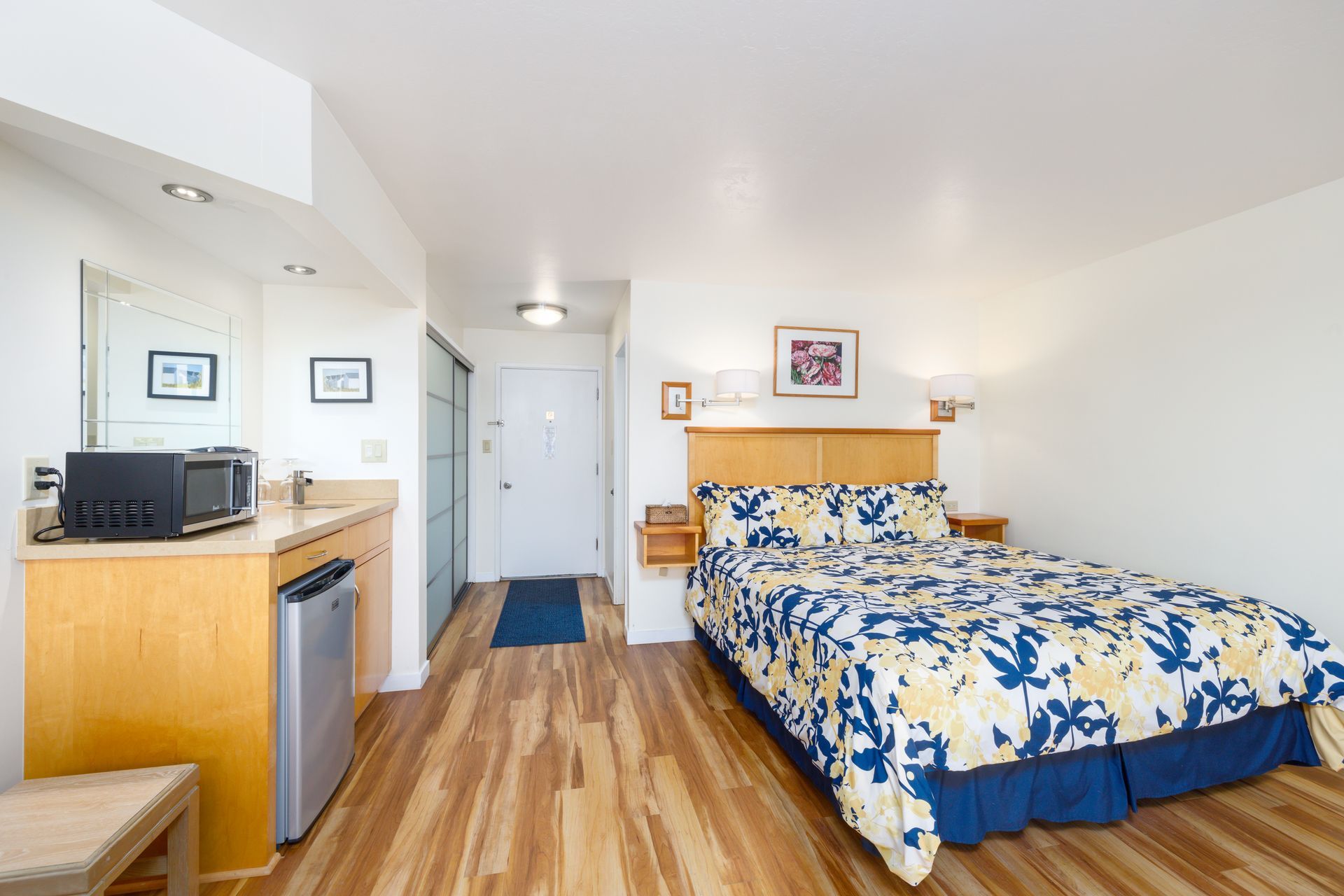 A hotel room with a king size bed and a microwave.