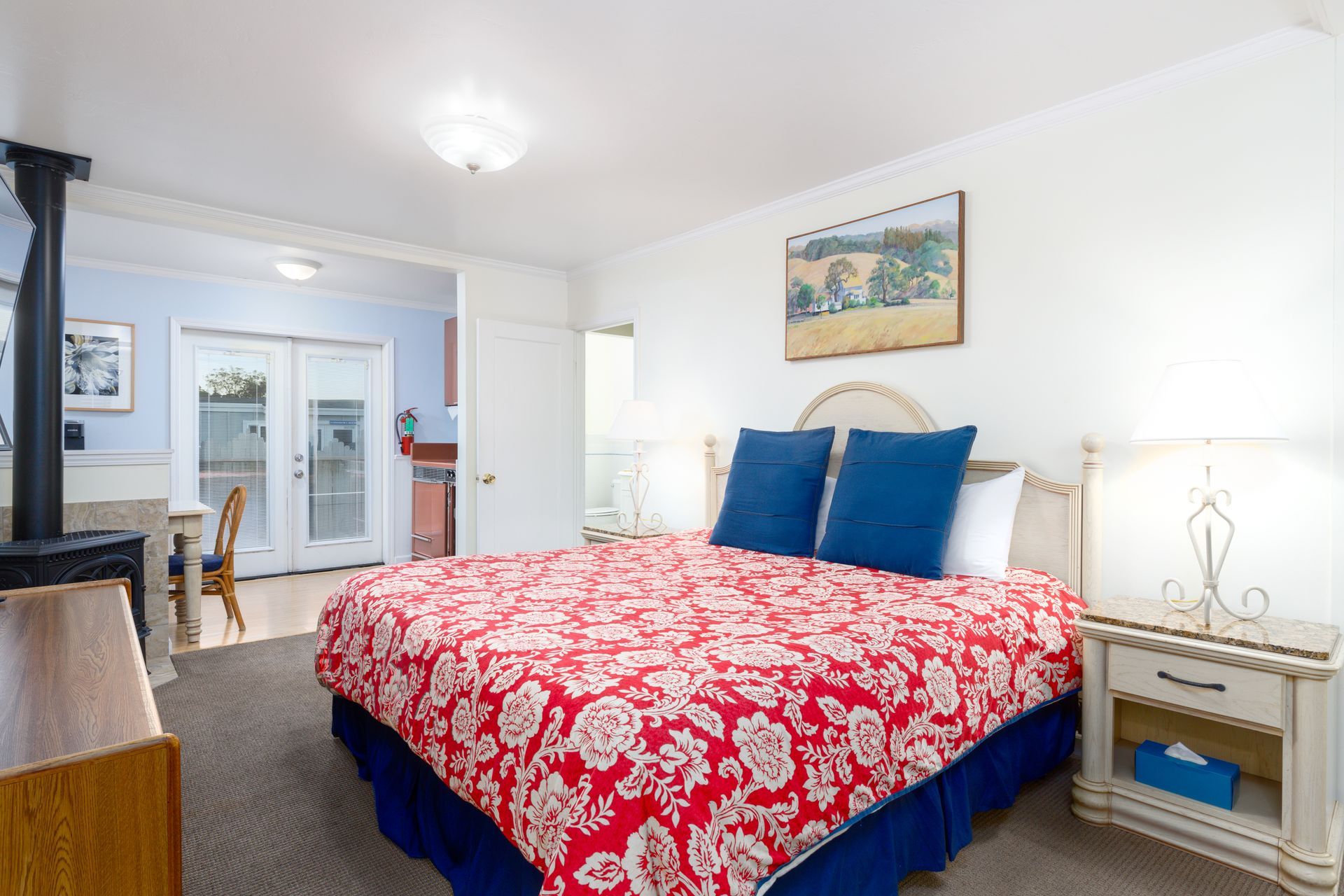 A hotel room with a king size bed and blue pillows