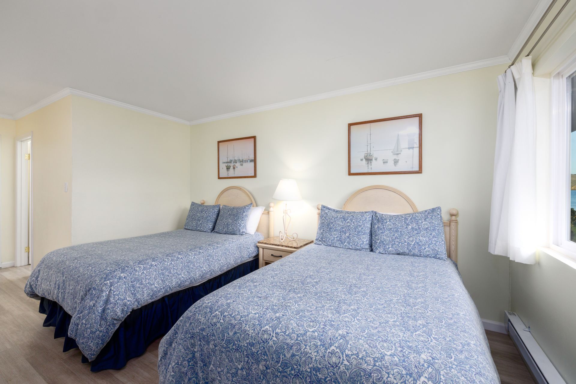 A hotel room with two beds and a window