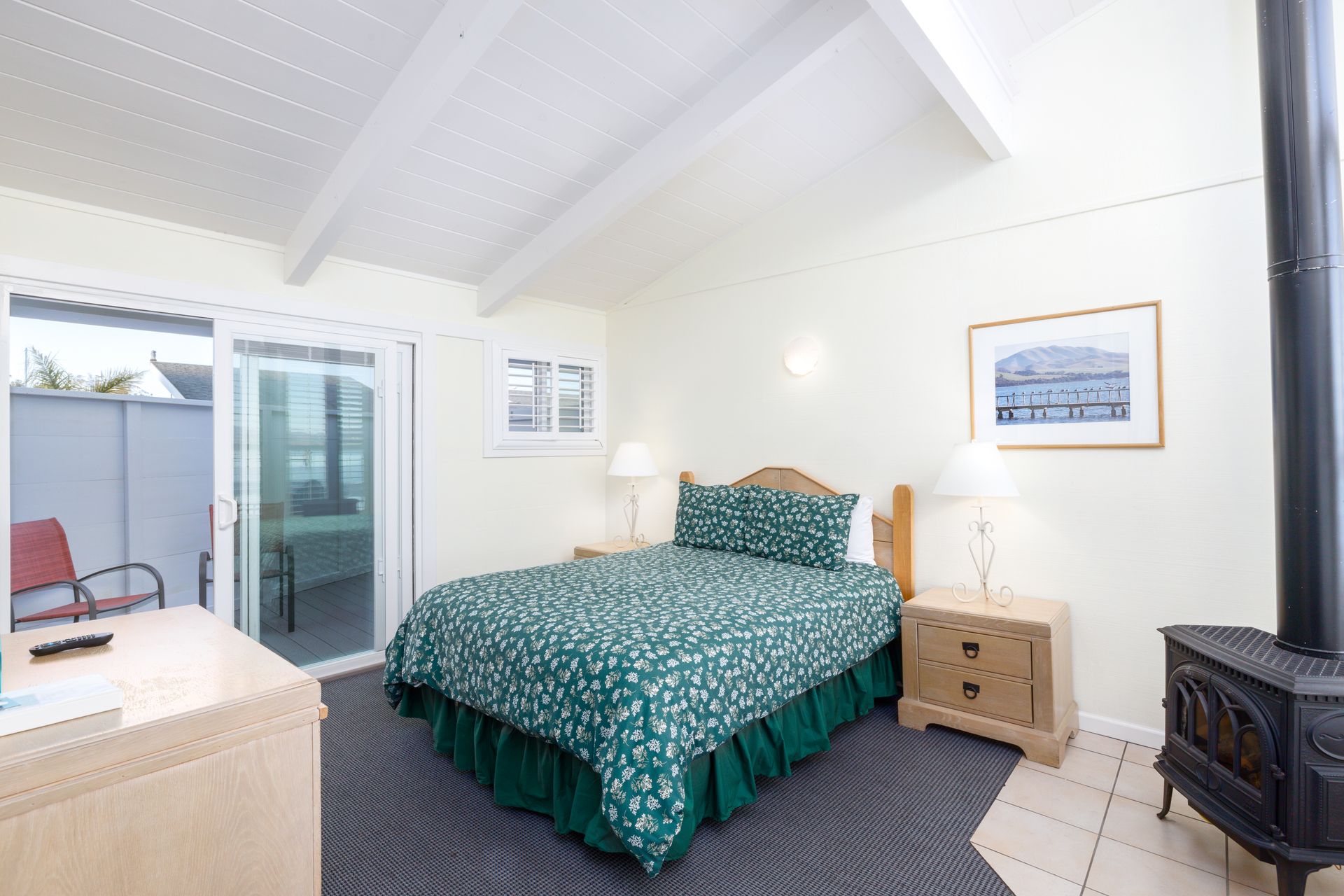 A bedroom with a king size bed and a wood stove