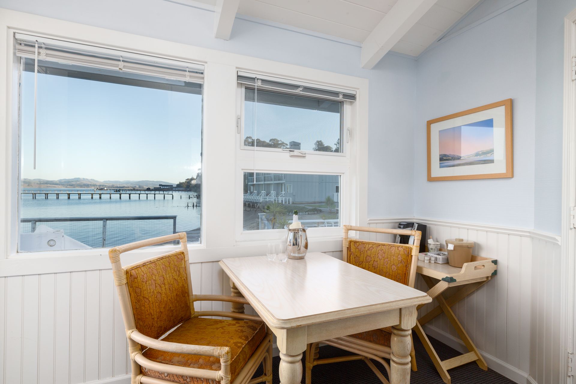 A table and chairs in a room with a view of the ocean