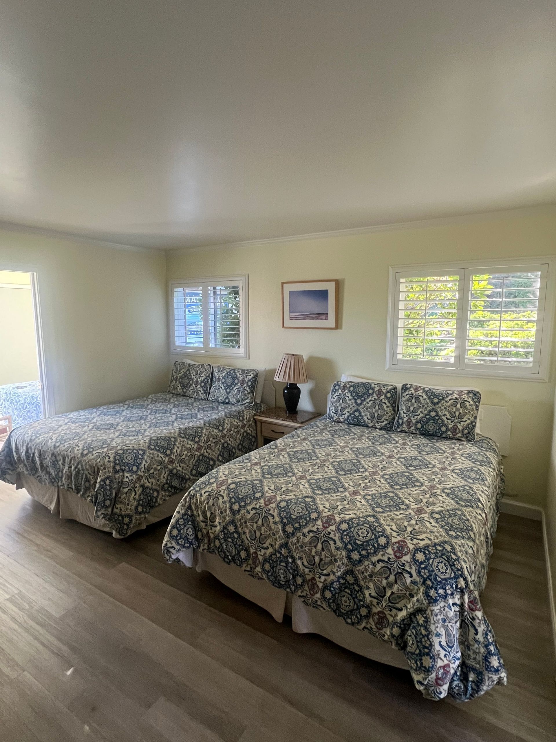 A bedroom with two beds and two windows.