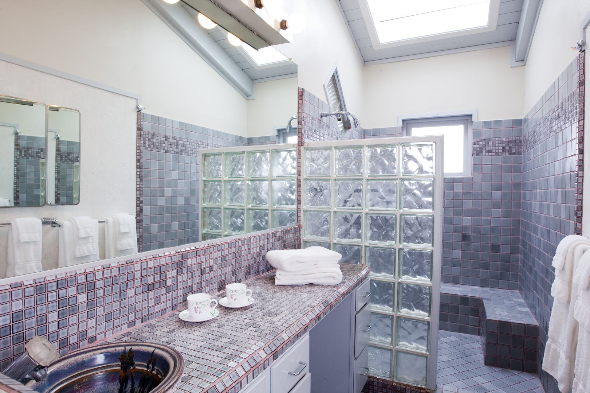 A bathroom with a sink and a walk in shower