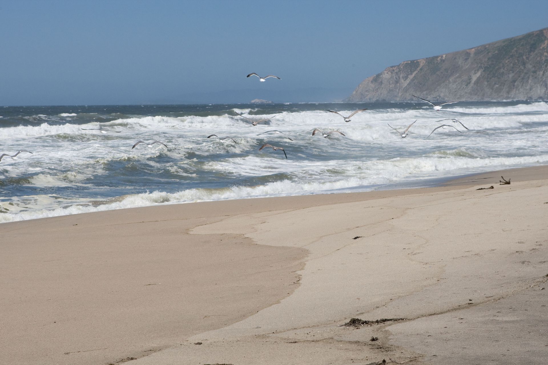 A sandy beach with waves crashing on the shore