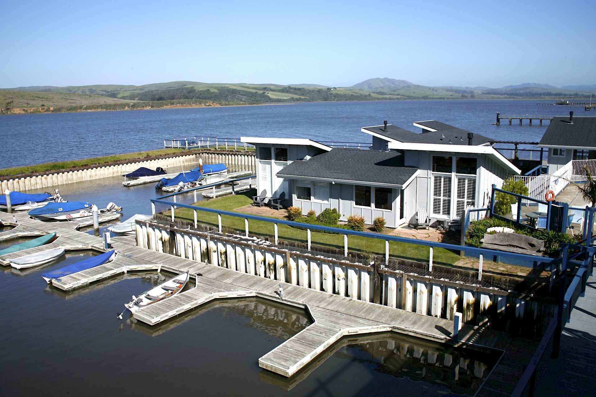 A marina with boats docked and a house in the background