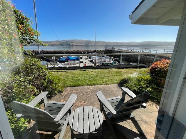 A patio with two chairs and a table with a view of the water.