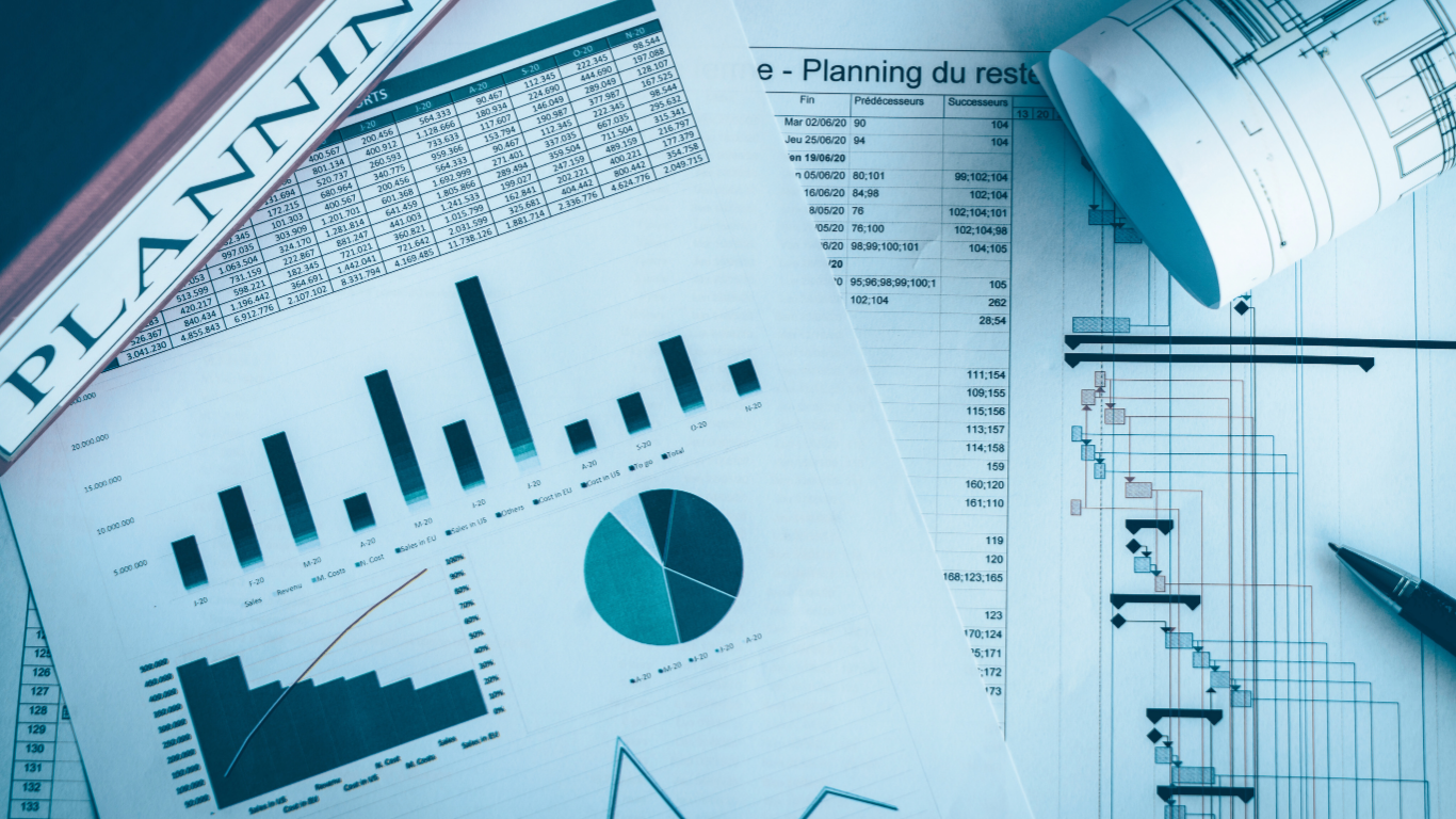 Charts, graphs, and documents on a desk, suggesting planning and financial analysis.