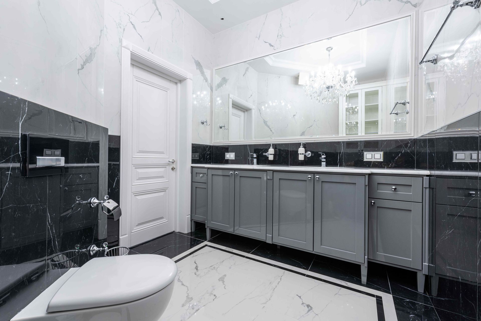 bathroom with grey cabinets and large mirror