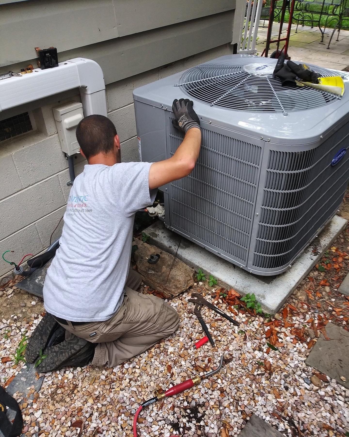 A technician working on residential air conditioning servicing for a home in Richmond, VA