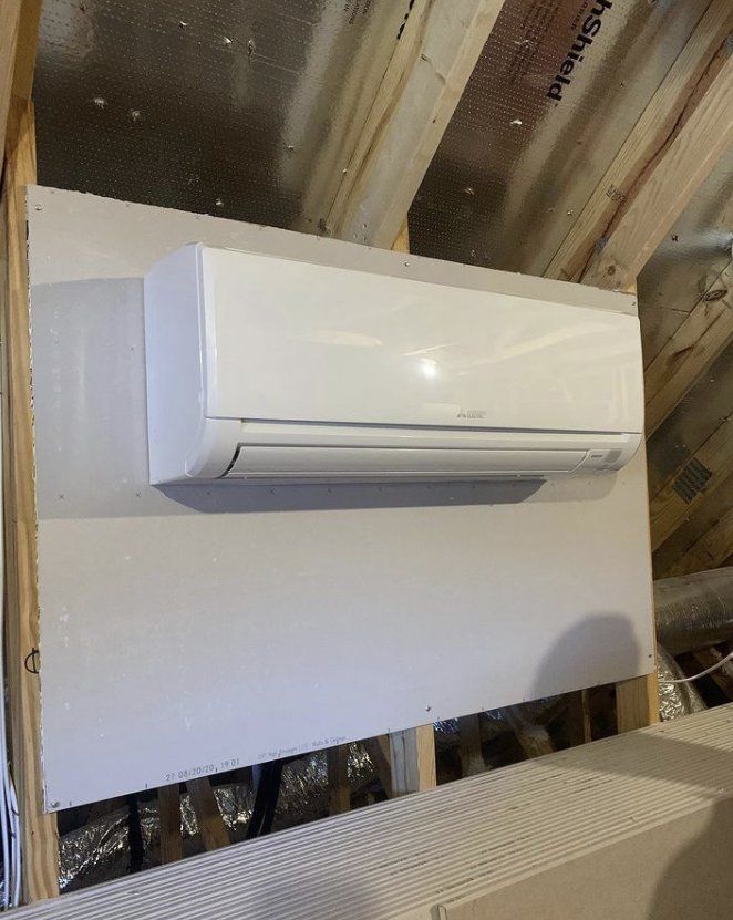 A white air conditioner is hanging from the ceiling in a room.