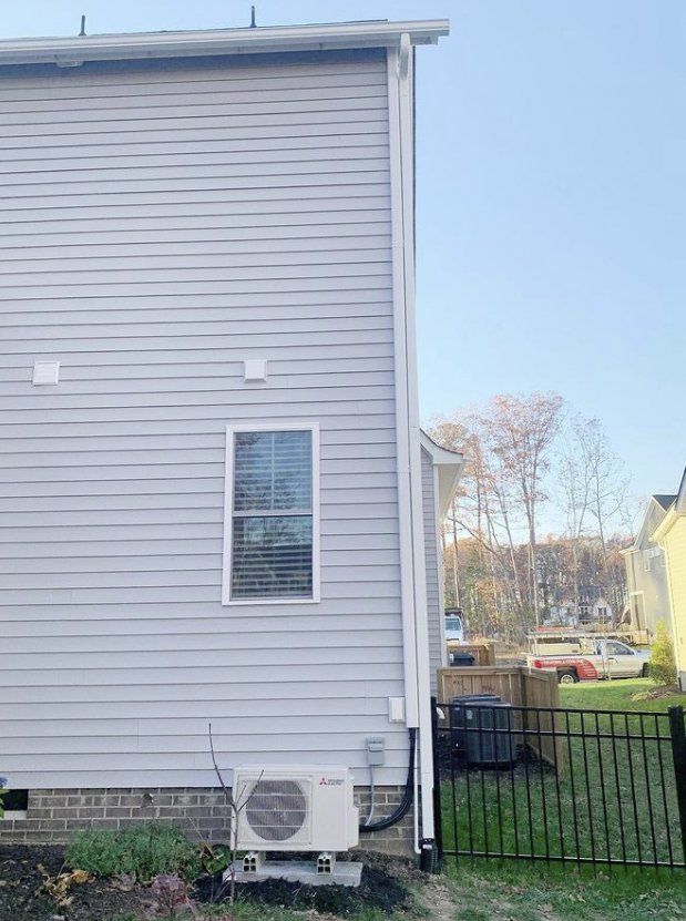 A white house with a window and an air conditioner on the side of it.