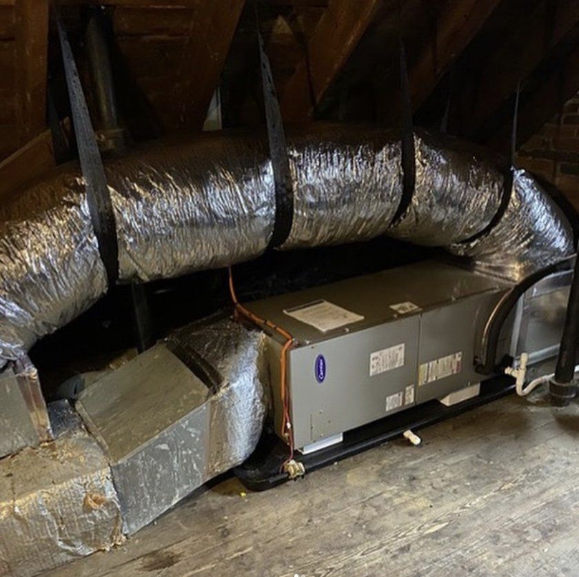 An air conditioner is being installed in the attic of a house