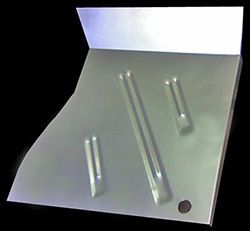 Silver metal panel with raised ribs and a folded-up edge. A black hole is visible.