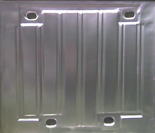 Metal panel with four rectangular indentations and vertical lines. Each indentation has a small, oblong hole.