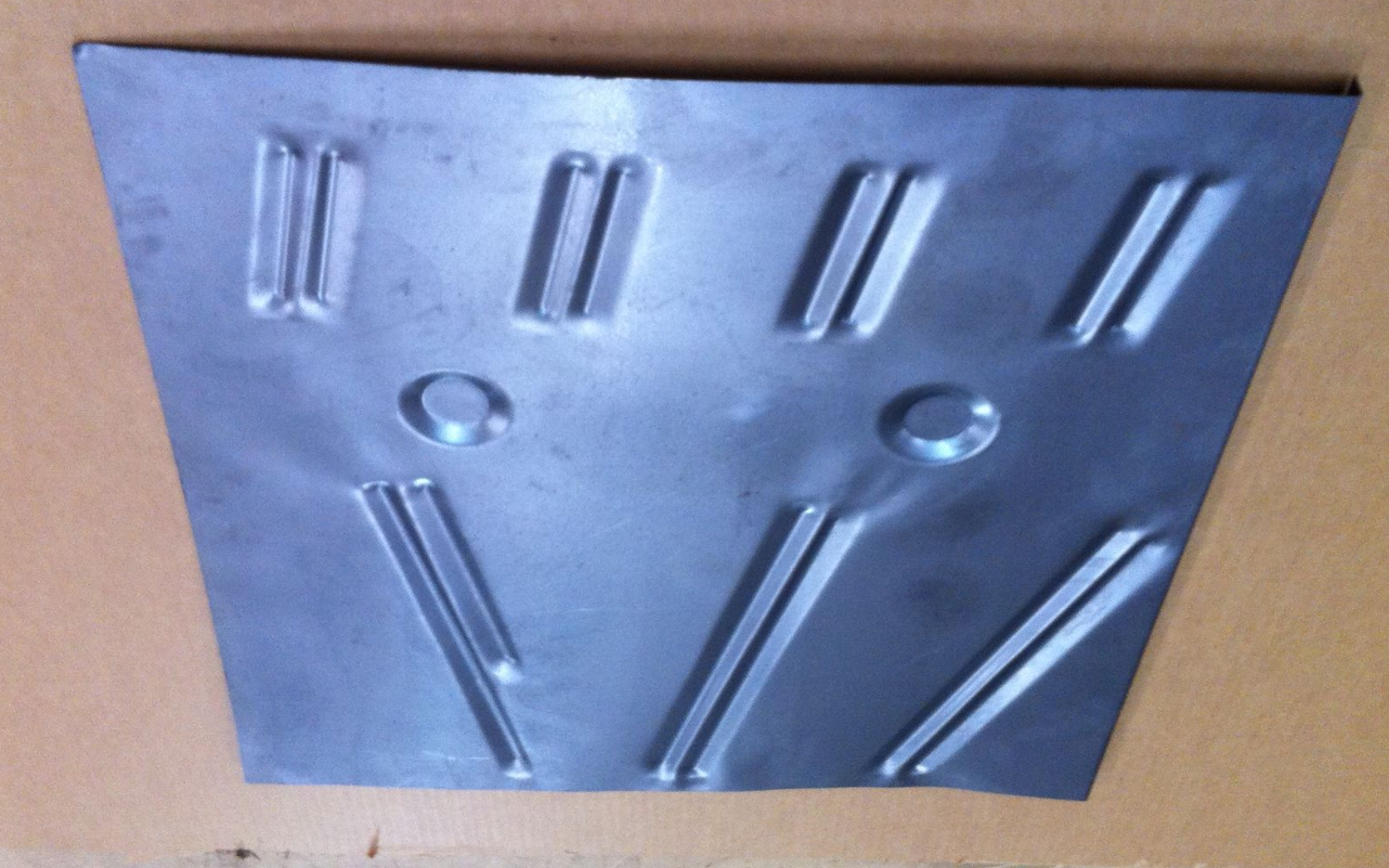 Metal floor panel with raised ribs and circles.