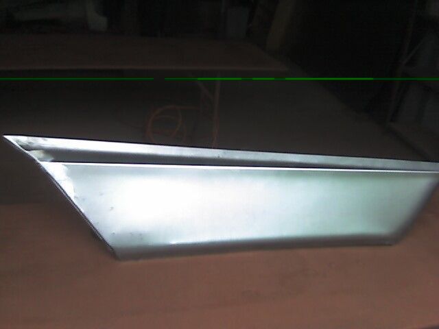 Metal side panel, angled edges, reflecting light.