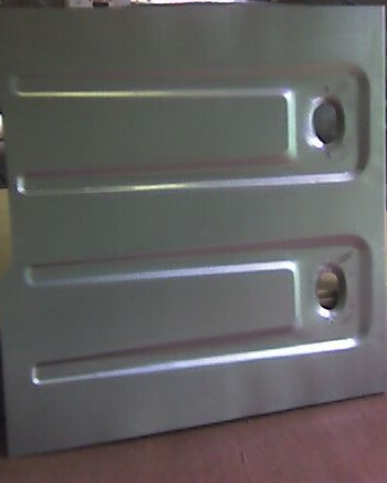 A rectangular, metallic gray panel with two recessed rectangles and circular holes.