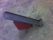Dark gray metal bracket with a red base on a gray surface.