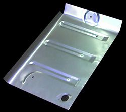 Silver metal car floor panel with ribbed reinforcement and holes.