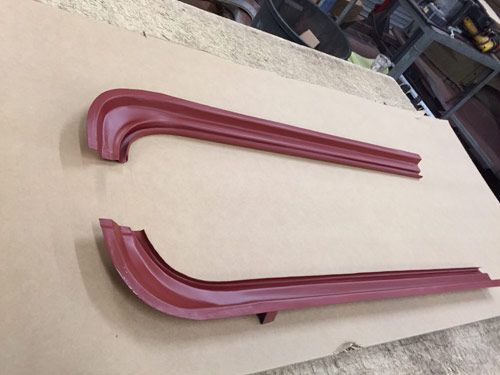 Two red car body trim pieces on a neutral background.