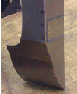 Black plow blade on a metallic surface, likely in an agricultural setting.