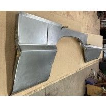Silver metal car fender on a wooden surface.