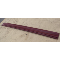 Long, maroon-colored wooden trim piece lying diagonally on a light brown surface.