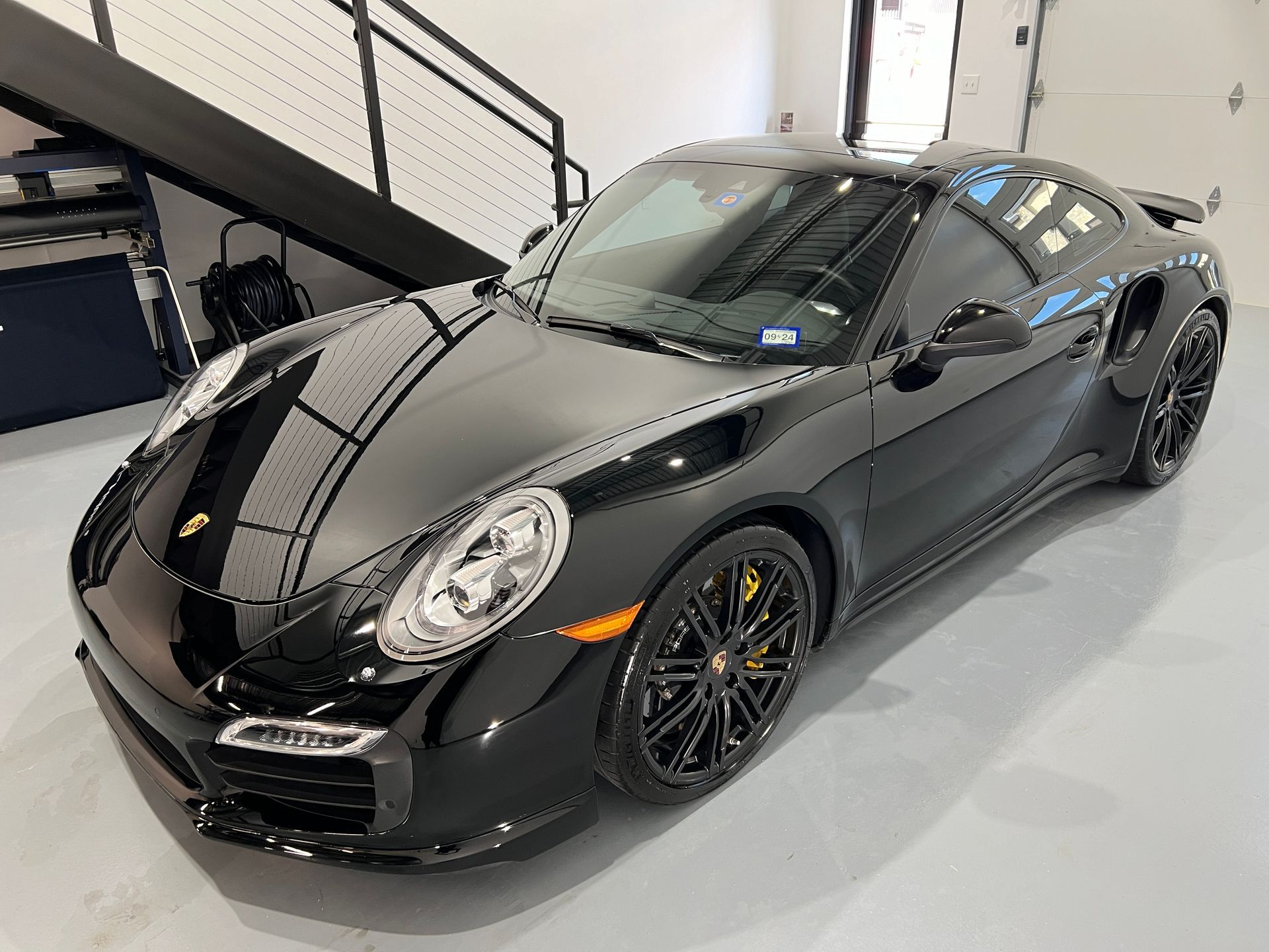 Black Porsche sports car parked indoors.