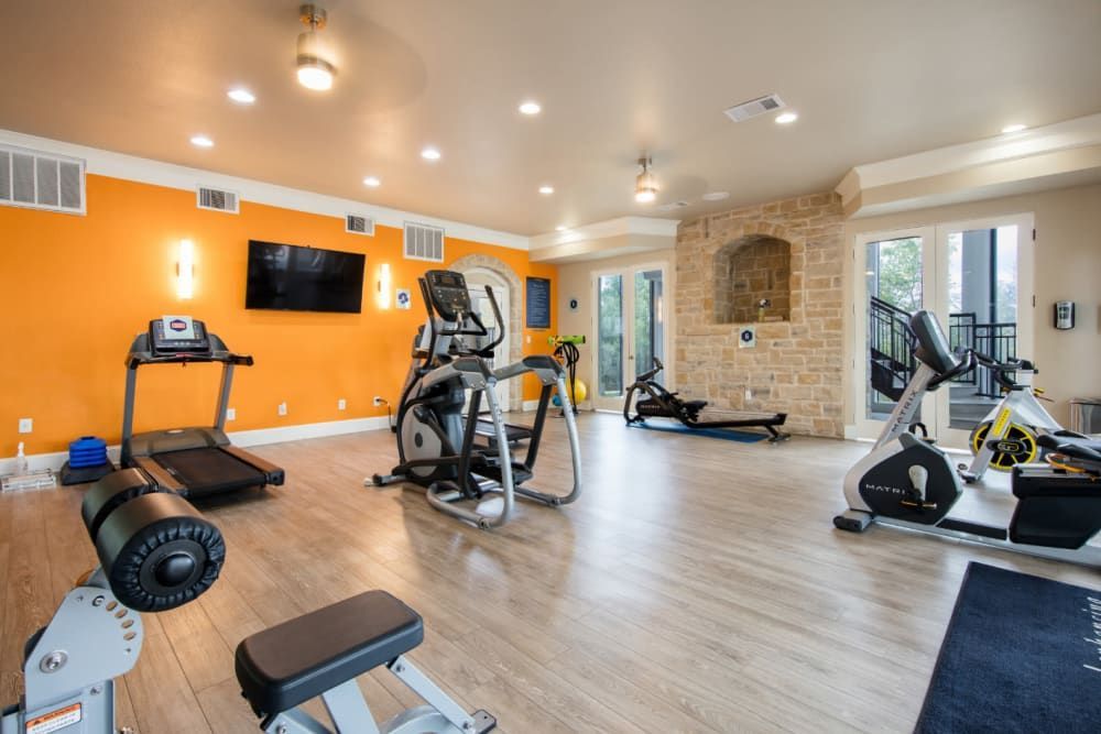 A spacious fitness center with many different types of exercise equipment at Marquis at Treetops in Northwest Austin, TX.