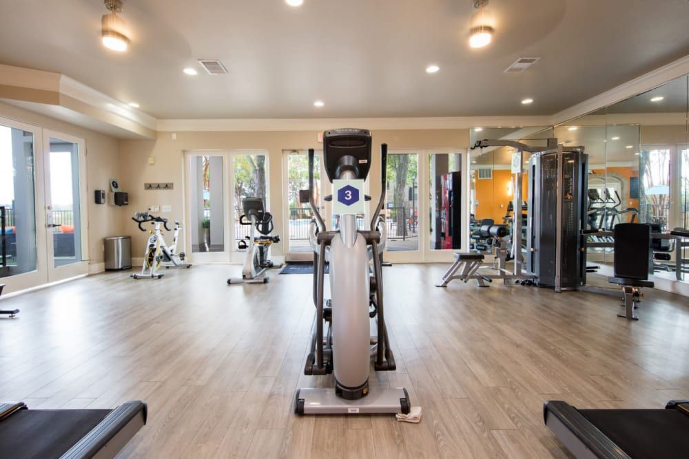 A large gym with a lot of exercise equipment and a treadmill at Marquis at Treetops in Northwest Austin, TX.