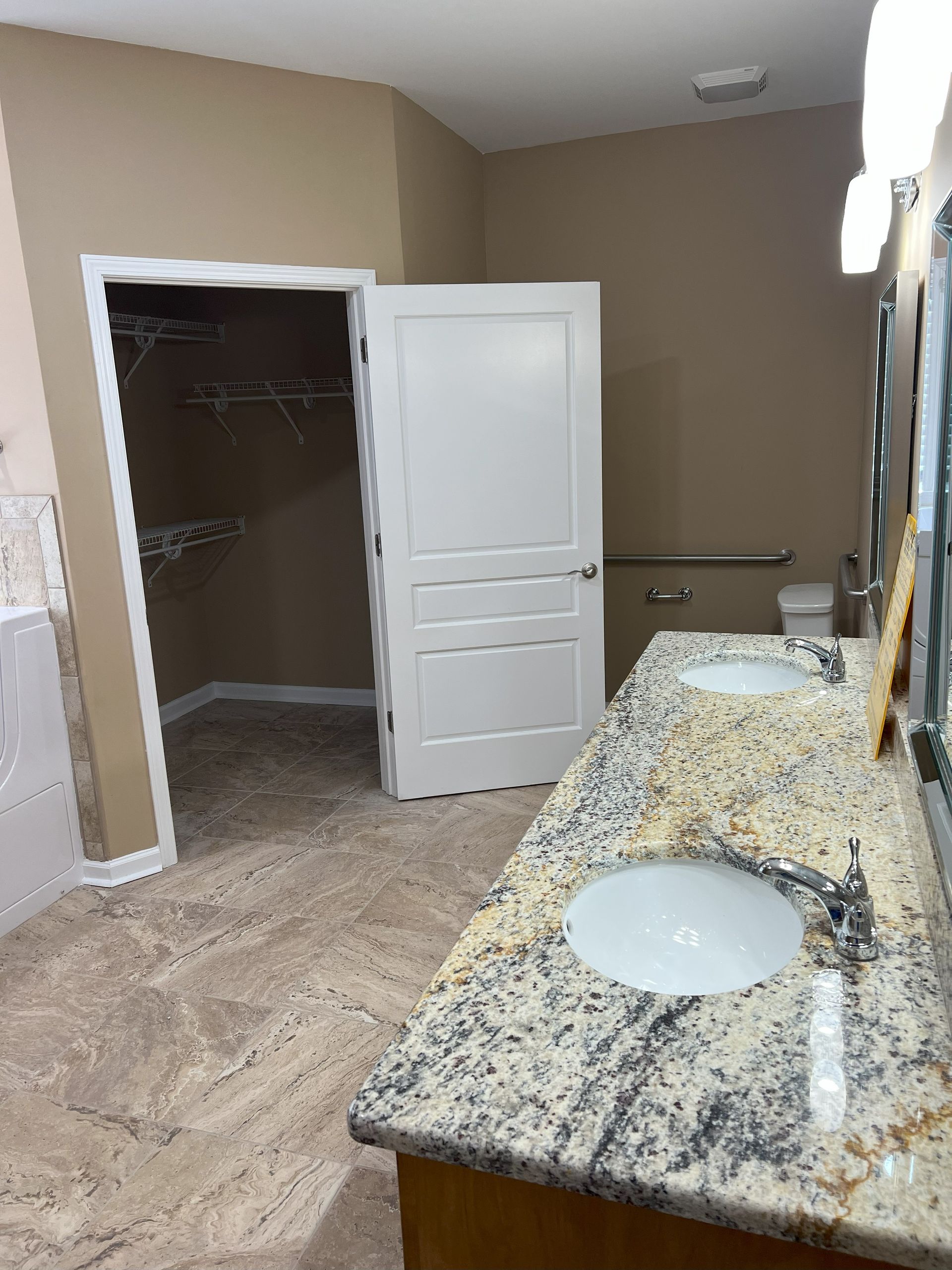 A bathroom with two sinks , a toilet and a walk in closet.