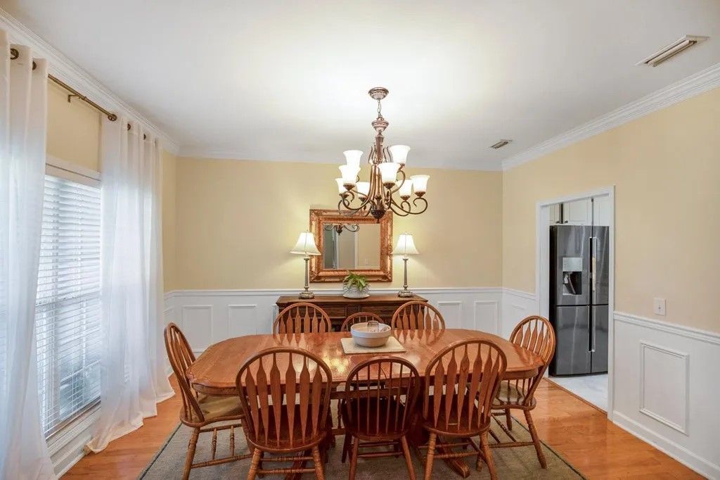 A dining room with a table and chairs and a chandelier.