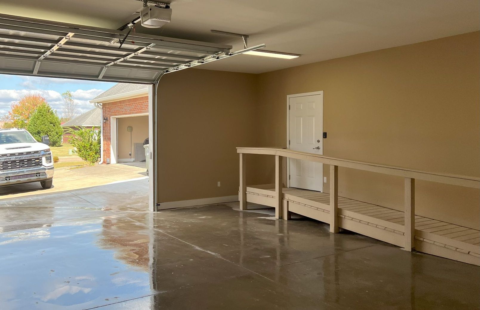 A truck is parked in a garage with the door open.