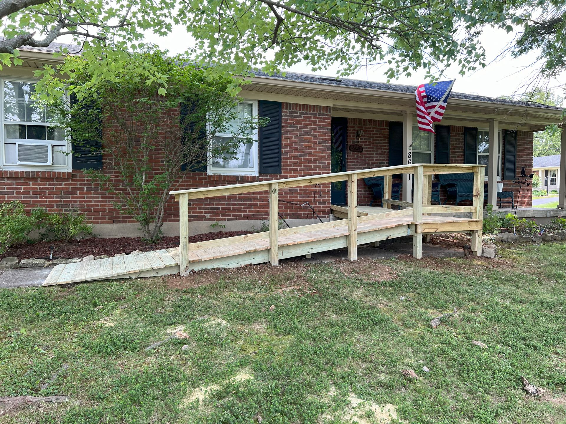 A wooden ramp is sitting in front of a brick house.