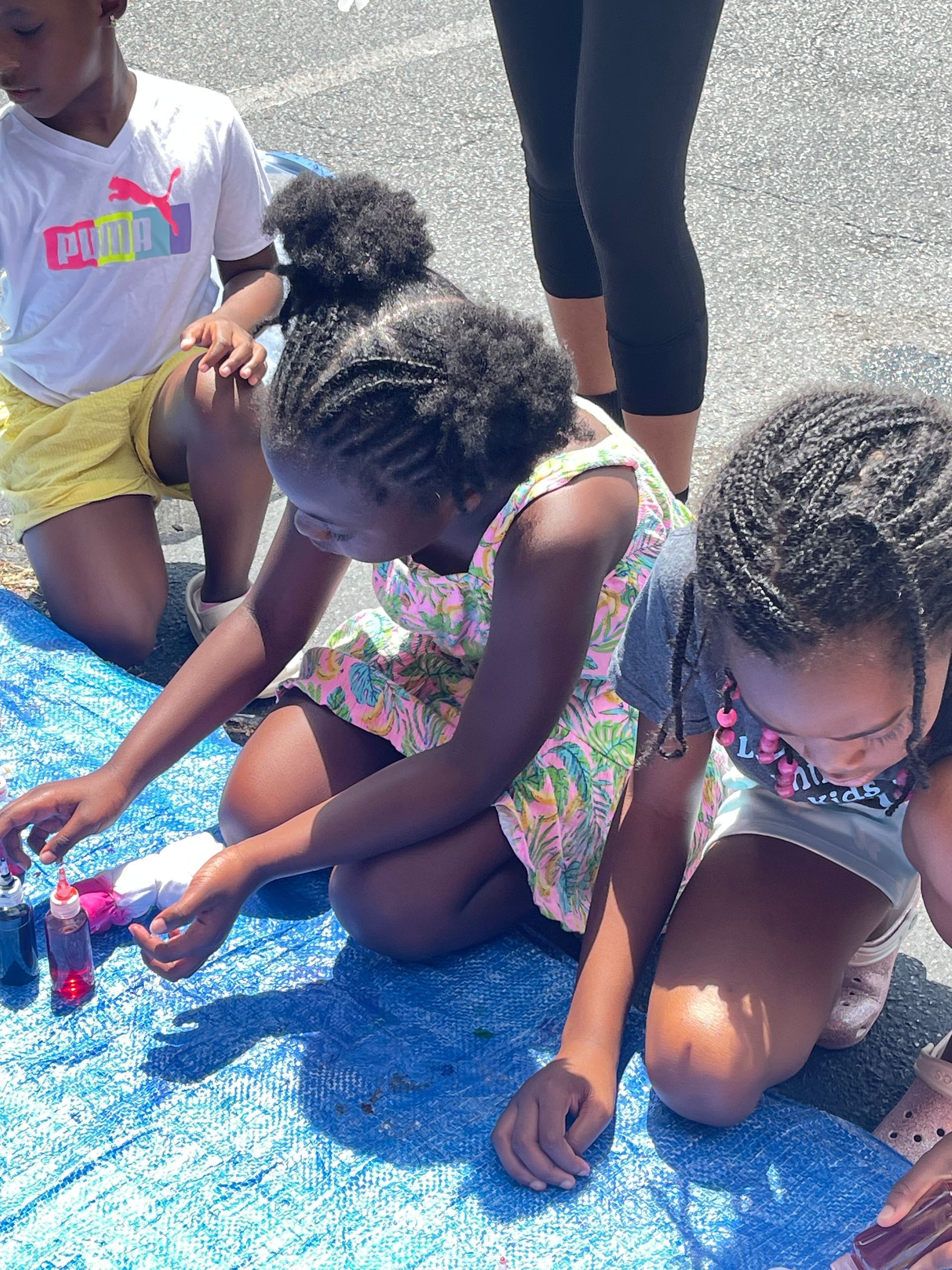 Young child with blond hair holding an orange ball, smiling in a playroom.