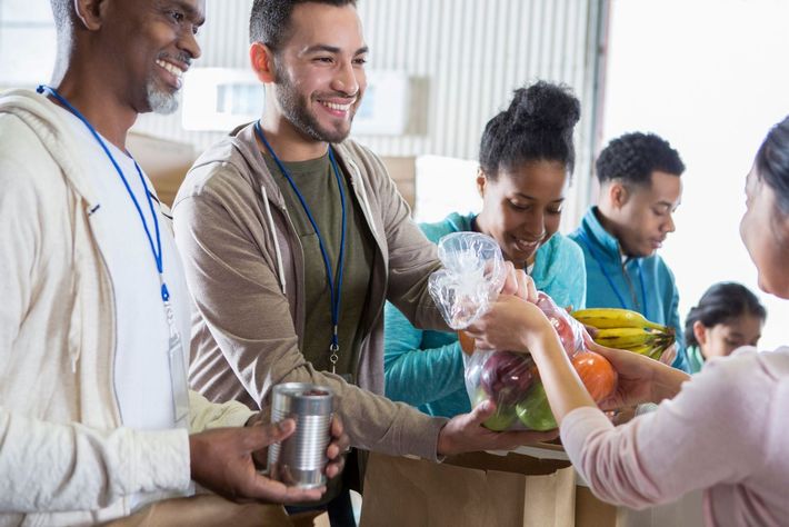 A group of people are giving food to a woman.