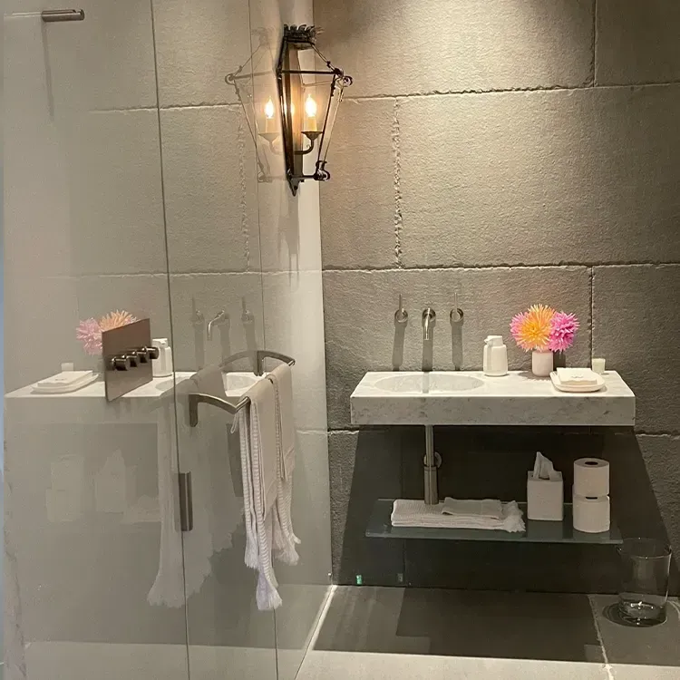 A bathroom with a sink and a lantern on the wall