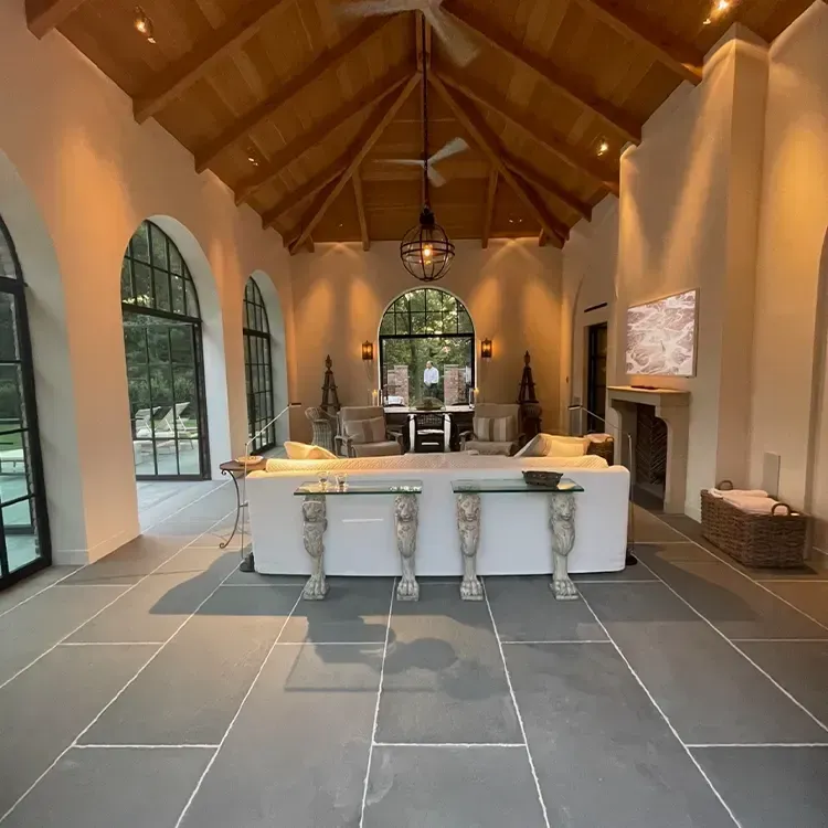 A living room with arched windows and a ceiling fan