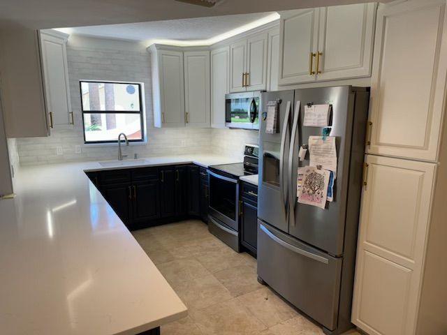 A kitchen with stainless steel appliances and white cabinets