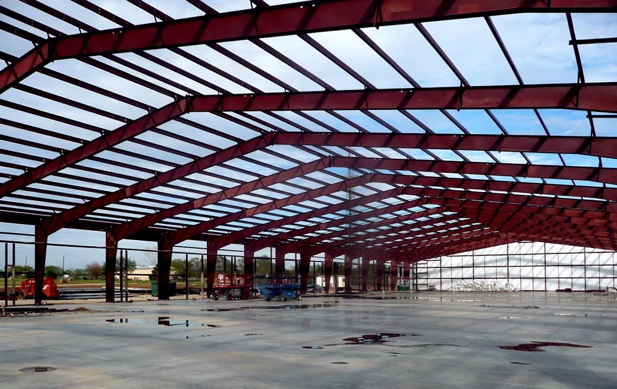 A large building under construction with a red roof