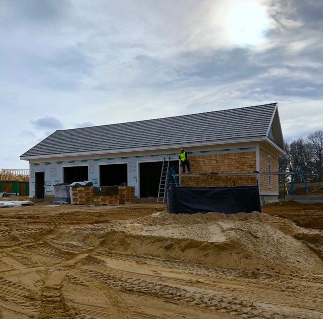 A man is standing on the roof of a building under construction.