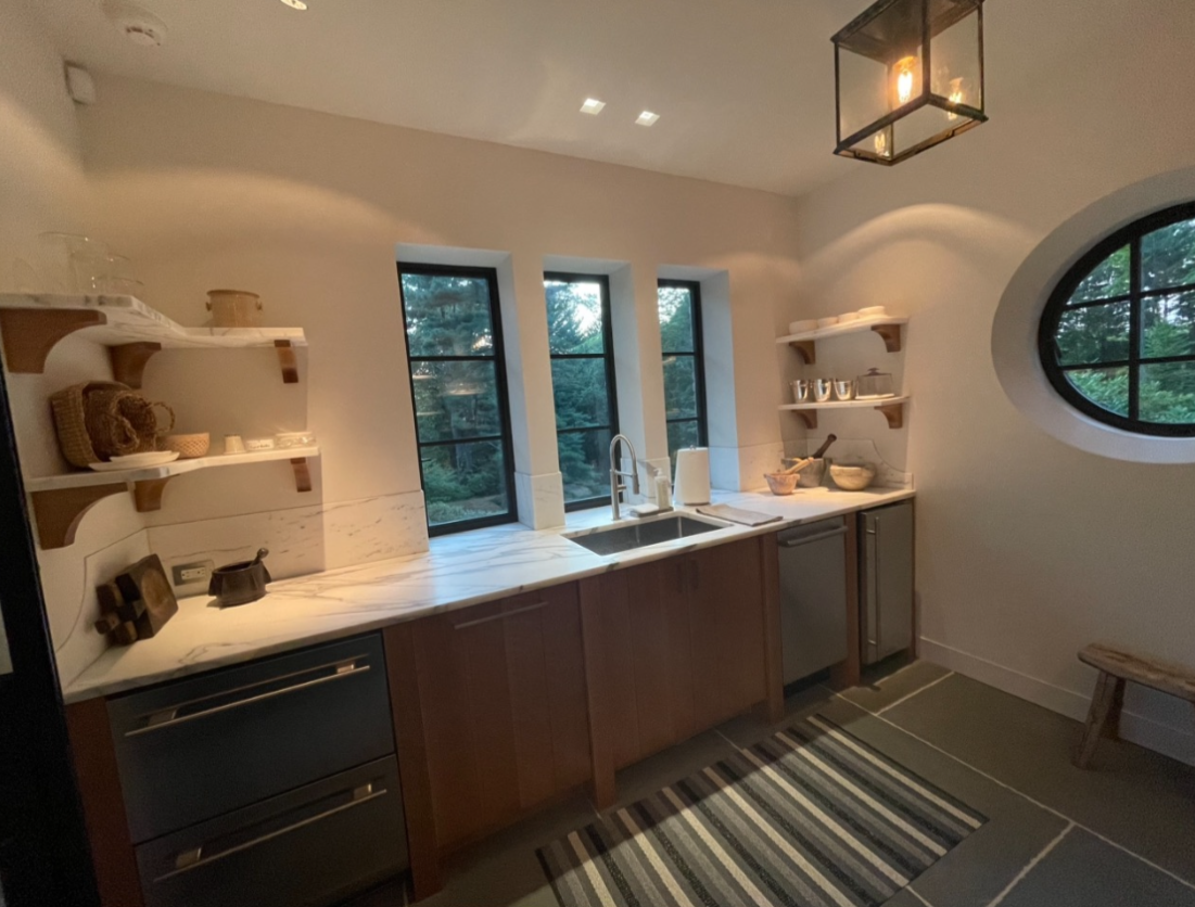 A kitchen with a sink and a round window