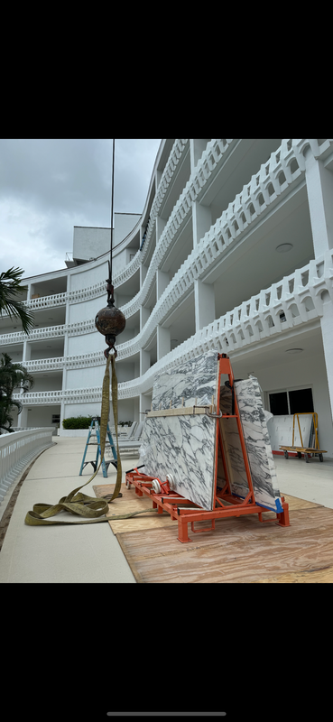A large white building with a crane in front of it.