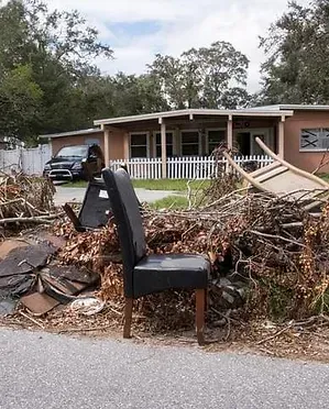 A chair is sitting on the side of the road in front of a house.