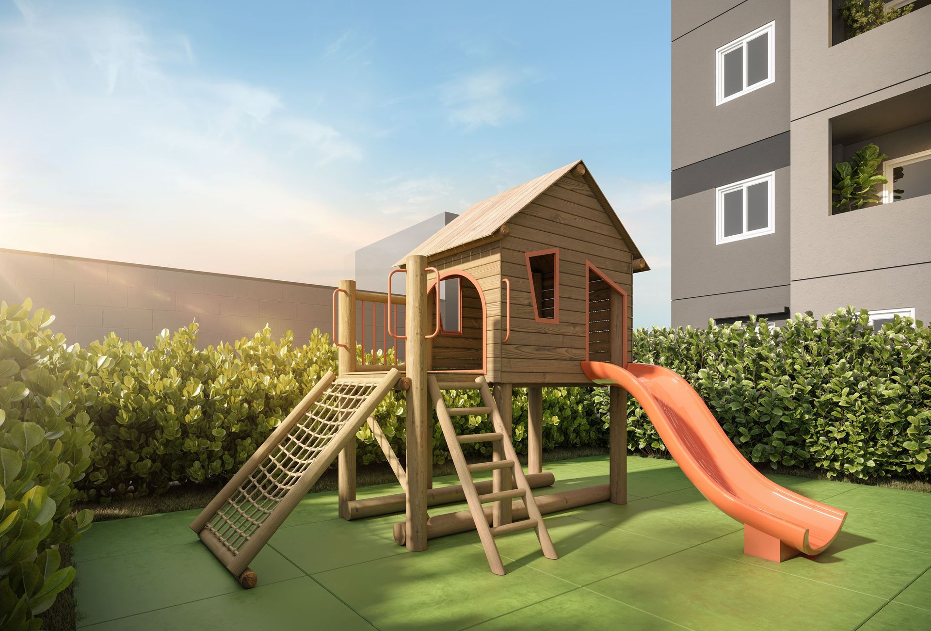 Parque infantil com estrutura de madeira, escorregador e rede de escalada, situado em gramado verde com um prédio ao fundo.