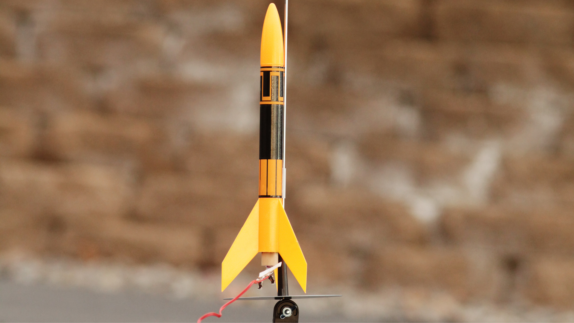A yellow and black rocket is sitting on a table.