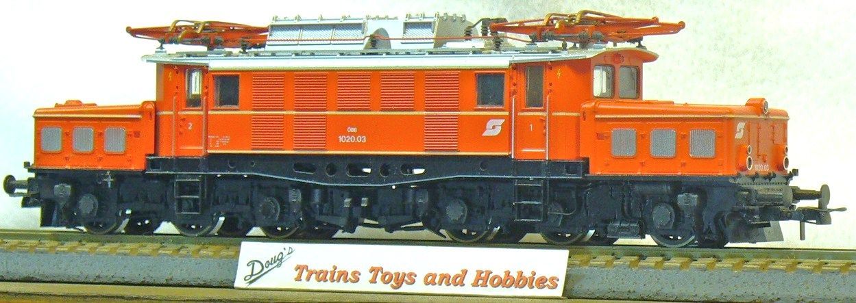 A model train is on display in front of a sign that says trains toys and hobbies