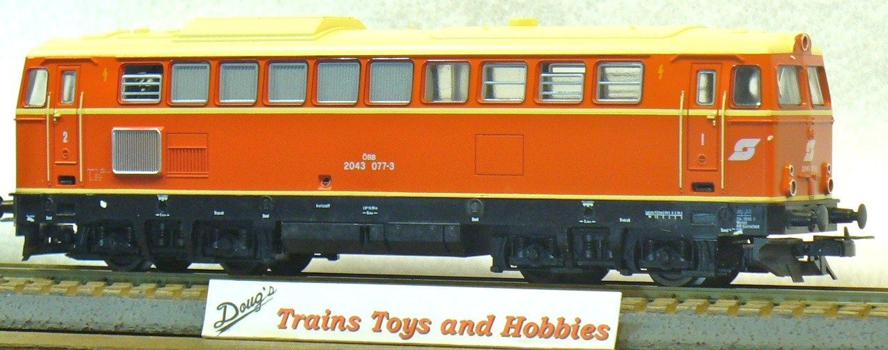 A model train sits on a track next to a sign that says trains toys and bobbles