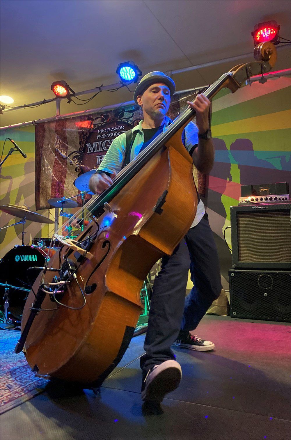 Ken Zeszutko is playing a double bass on a stage.